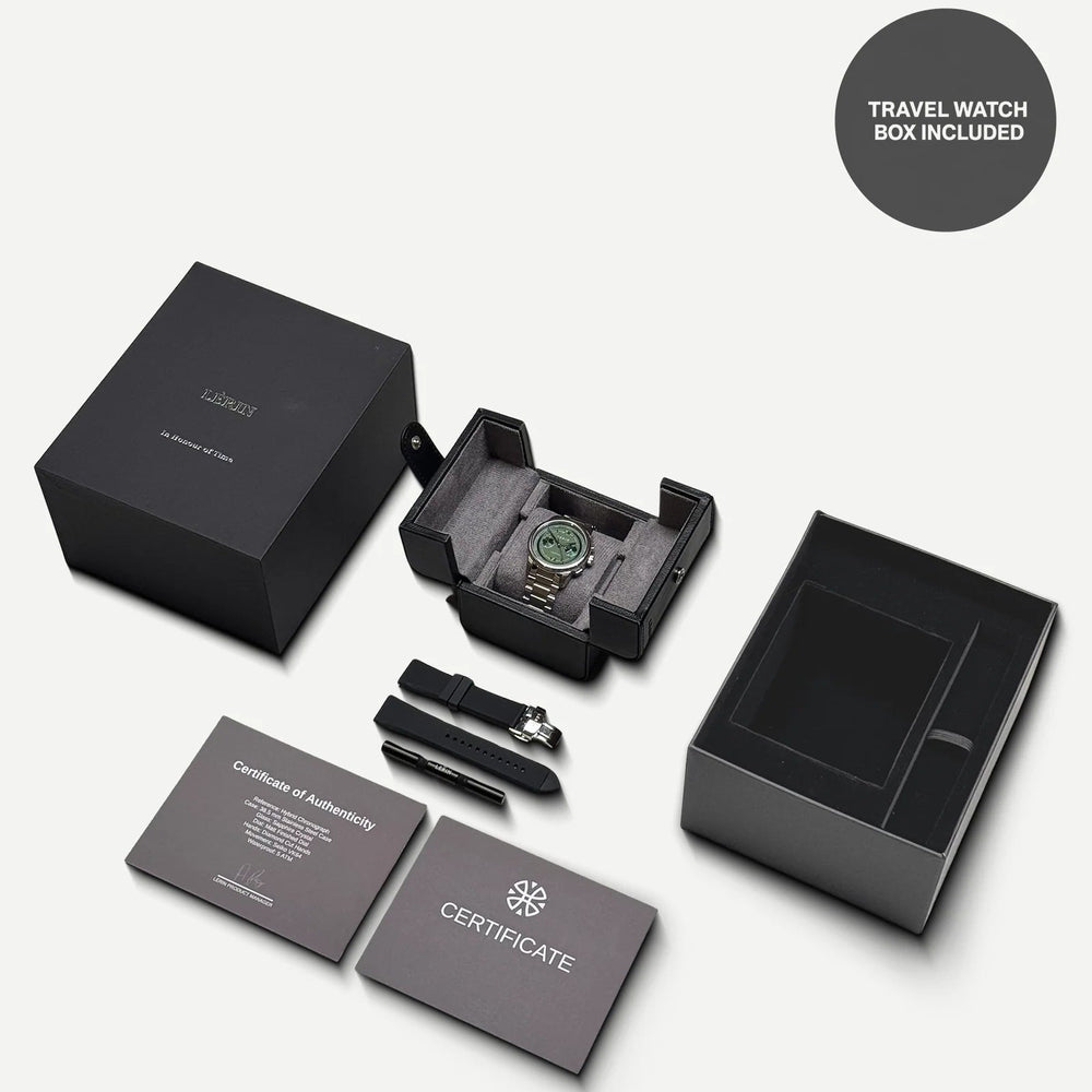 A luxury watch gift set shown on a light gray background, including a black watch box with a watch inside, a second black box, an open empty compartment box, two certificate cards, a black strap, and a small metal tool. A dark gray circle in the top right says 'TRAVEL WATCH BOX INCLUDED'.