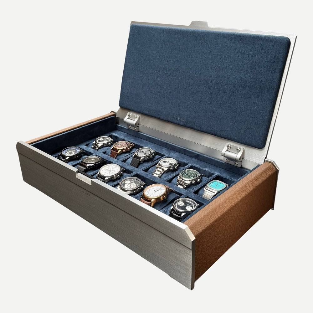 Open AUBLIQ silver 12-slot watch box displaying twelve watches on blue cushions, with brown side panels and a padded lid.