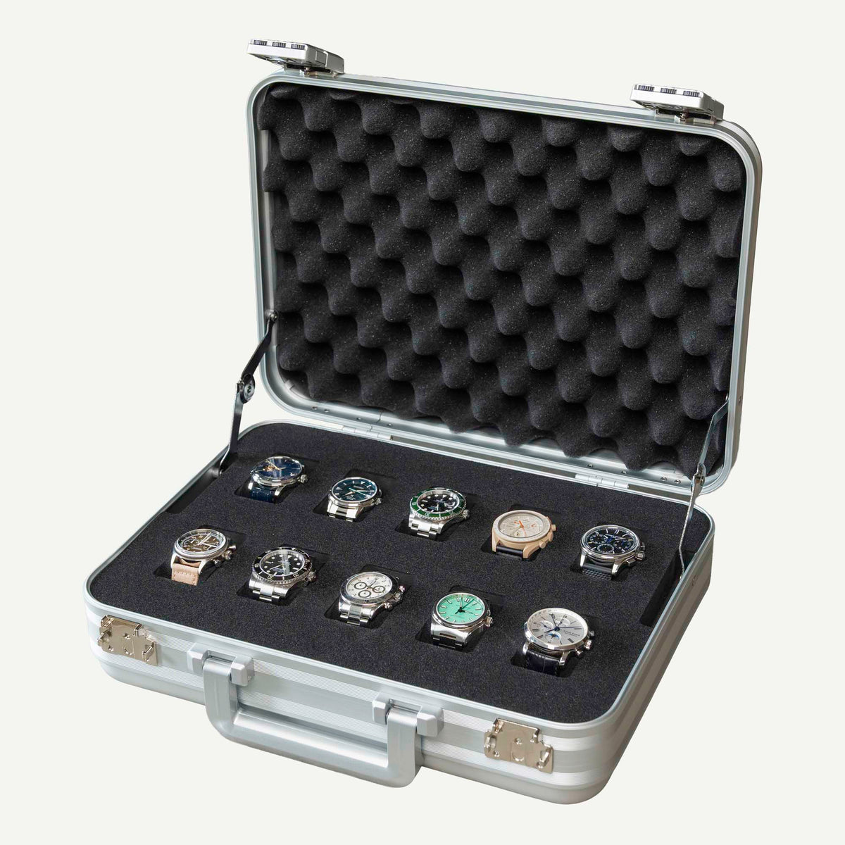 Open silver aluminium 10-slot watch box holding ten watches in black foam, with a padded lid and carry handle.