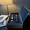 Side view of the open AUBLIQ silver 10-slot watch box, showing blue cushions, a padded lid and a brown end panel.
