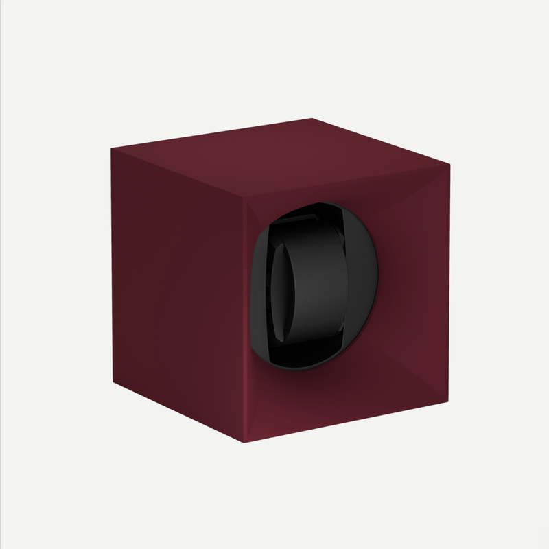 Maroon watch winder with a black watch inside on a white background