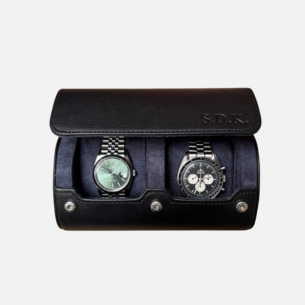 Black leather watch case with two watches on a light gray background
