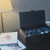 AUBLIQ black and brown 10-slot watch box with ten watches, blue lining, a covered strap compartment and soft close lid.